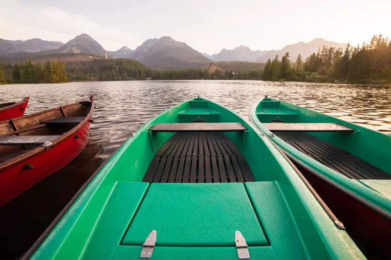 Stunning mountain lake with colorful wooden boat. National Park High Tatras, Strbske Pleso, Slovakia, Europe
